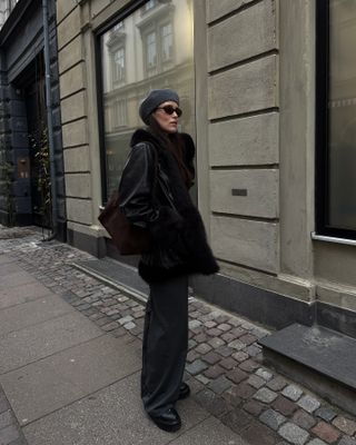 Annabel Rosendahl wearing a gray beret, black fur coat, black pants, and black shoes.