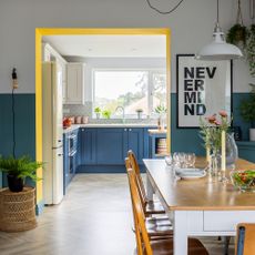 through dining room with yellow painted archway and wooden dining table and chairs