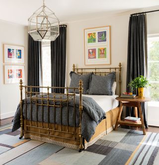 Gold poster bed, grey bedding and carpet, glass lightshde