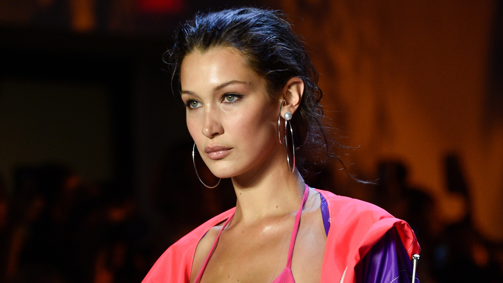 Model Bella Hadid walks the runway in a bikini and neon tracksuit top
