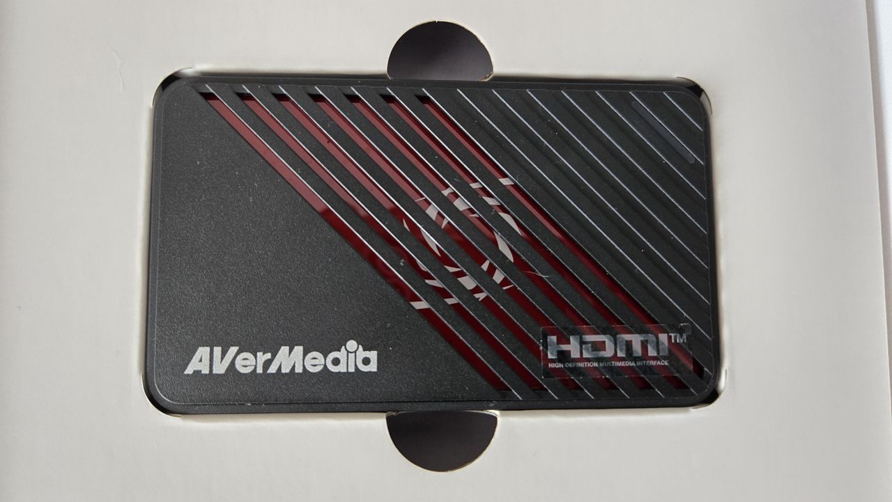 An AverMedia external capture card on a chair.