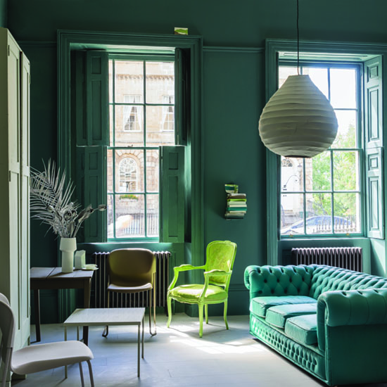 living room with teal green walls and button back sofa