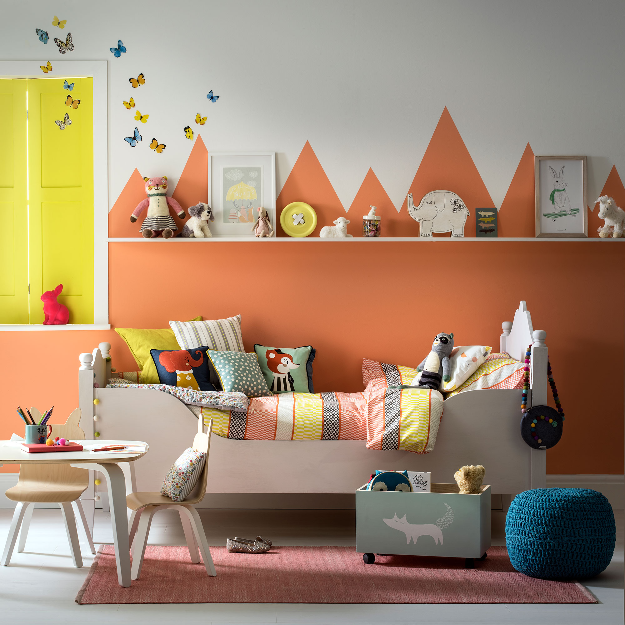 kids room with painted orange wall mural of mountains