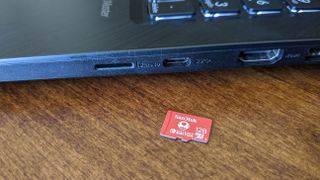 Larger microSD card next to laptop.