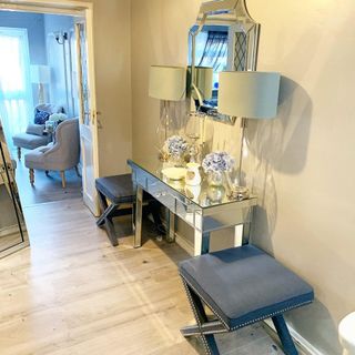 Shiny console table over parquet flooring with grey seats