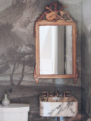 Powder room with gold mirror