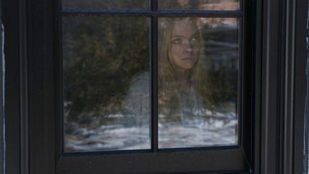 Amanda Seyfried looking out a window in The Housemaid.