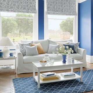 Blue living room with white sofa and styled coffee table