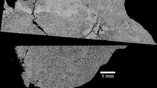 Two halves of a gray moon rock in front of a black background