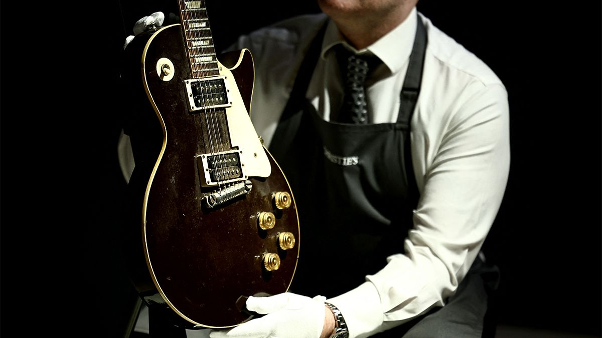 A Christie&#039;s art handler shows a Gibson Electric Guitar known as &#039;The Oxblood&#039; during a photocall ahead of Christie&#039;s auction &quot;Jeff Beck: The Guitar Collection&quot;, in London, on January 14, 2025. 