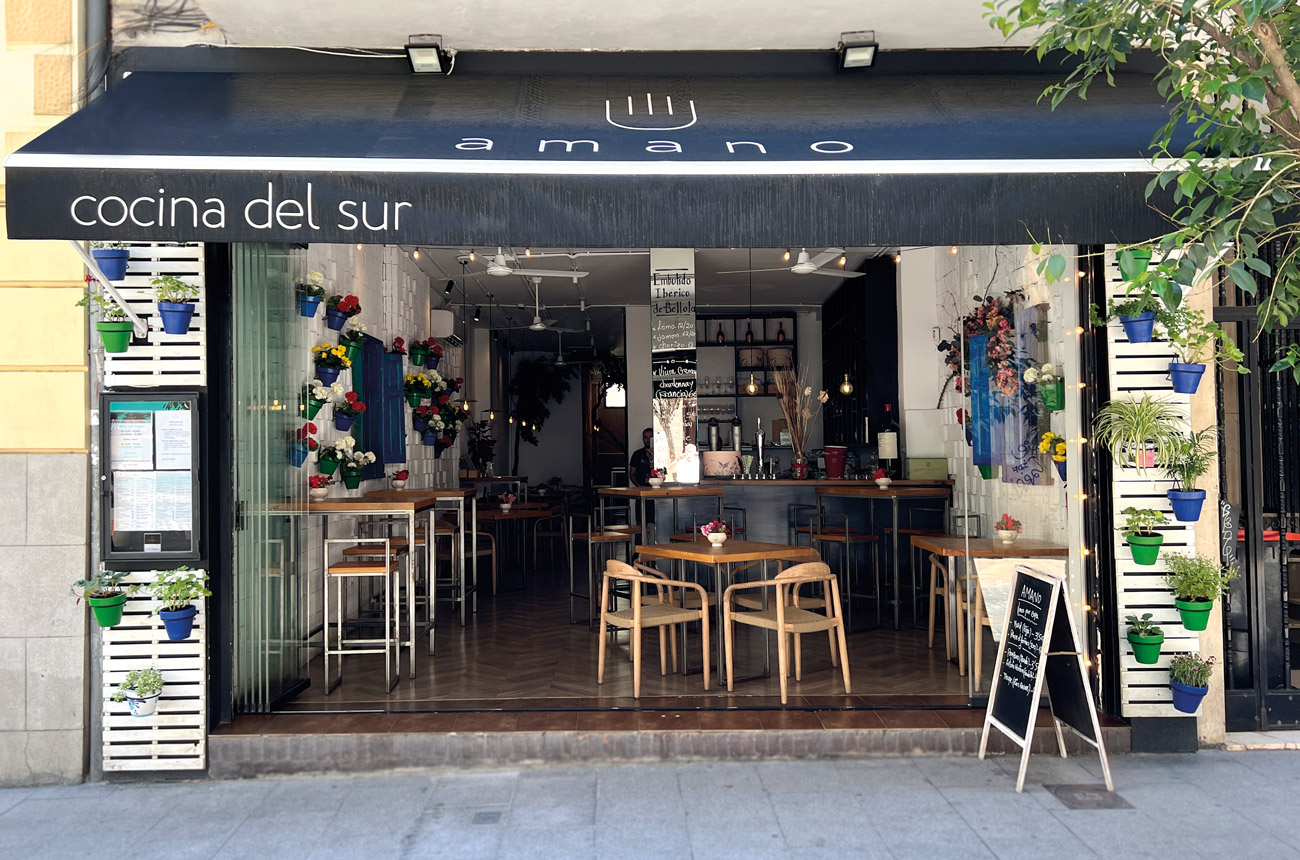 Street view of a restaurant with open front and tables and chairs