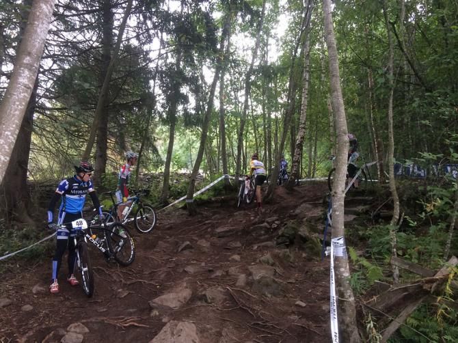 Riders assess one of the technical, uphill rock garden sections
