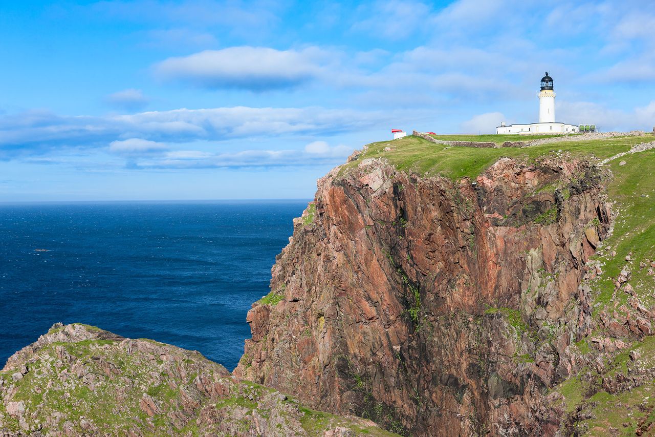 Cape Wrath, the most northwesterly point of the UK mainland. The lighthouse, built in 1828, sits above a massive, richly coloured rockface and provides a beacon for shipping passing between the North Atlantic Ocean and the North Sea.