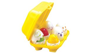 A yellow plastic egg box with six colourful toy eggs inside. TOMY Toomies Hide and Squeak Eggs.
