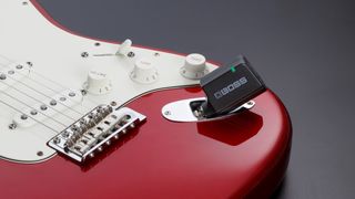 Boss WL-50 review: Boss WL-50 transmitter plugged into a red Fender Stratocaster on a grey background