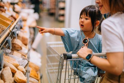 Mum and young daughter shopping at the supermarket