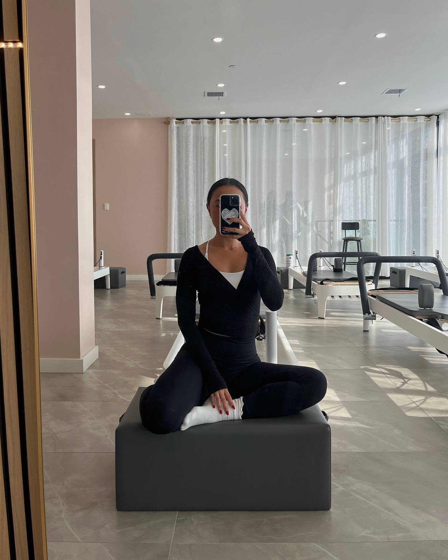 A woman wearing a black workout set in a Pilates class
