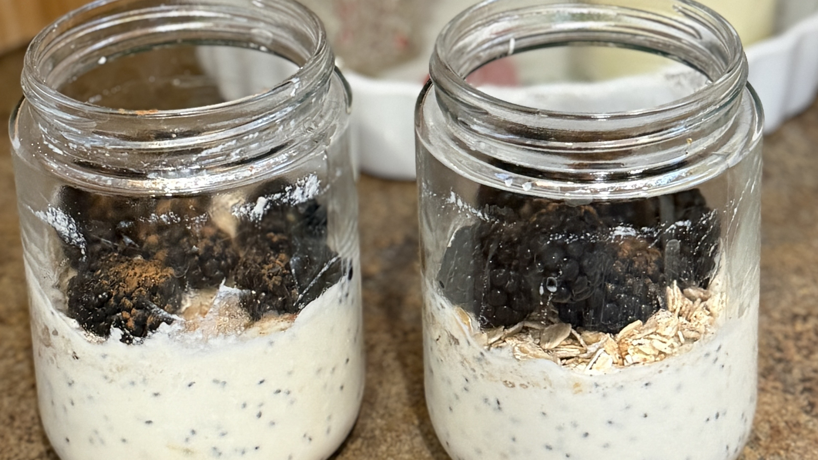 Two jars of overnight oats topped with blackberries