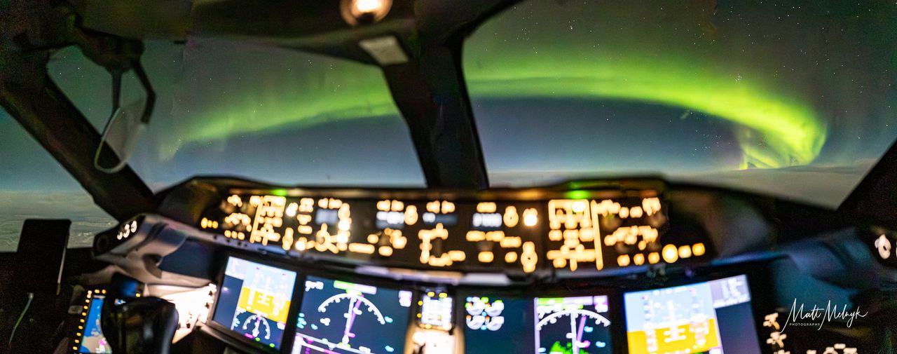 ribbons of green and purple light fill the sky in photos captured above the clouds from a dreamliner airplane.