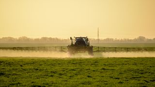 A tractor spraying chemicals on a field. 