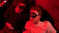A couple wearing Pitchblack Playback eye masks holding hands in the dark.