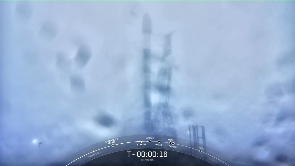 rainy and foggy camera view of starlink satellites atop a falcon 9 rocket. at bottom is a countdown clock frozen at t-16 seconds