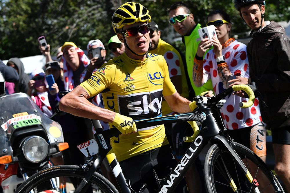 Chrtis Froome looks for his team car after his bike was damaged in a crash