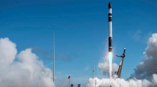 a black-and-white rocket lab electron rocket launches into a blue sky 