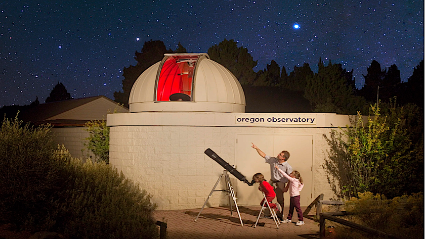 a domed observatory with a family stargazing