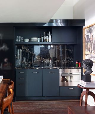 Galley kitchens shown in a midnight blue single galley kitchen with black granite backsplash.