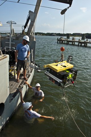 Research team members get in the water to test the Remotely Operated Vehicle (ROV) that will carry the cameras developed at WHOI's Advanced Imaging and Visualization Lab.