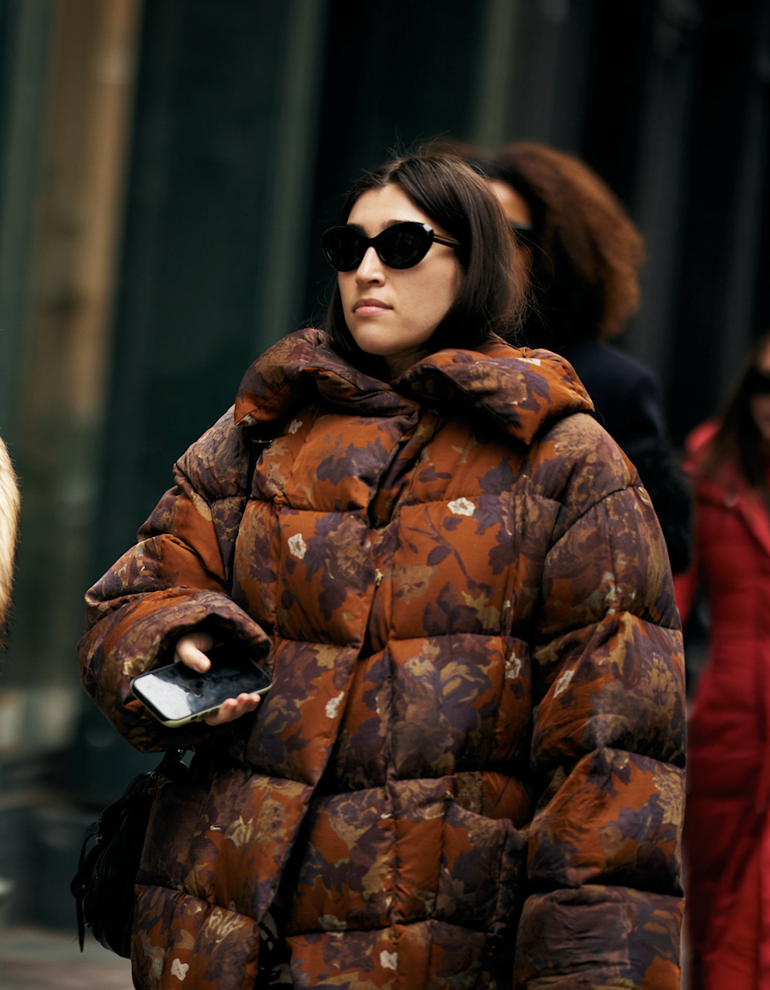 a woman in new york city wearing a brown and purple floral puffer jacket