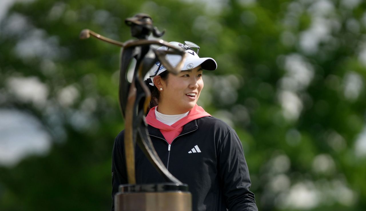 Rose Zhang looks at a trophy