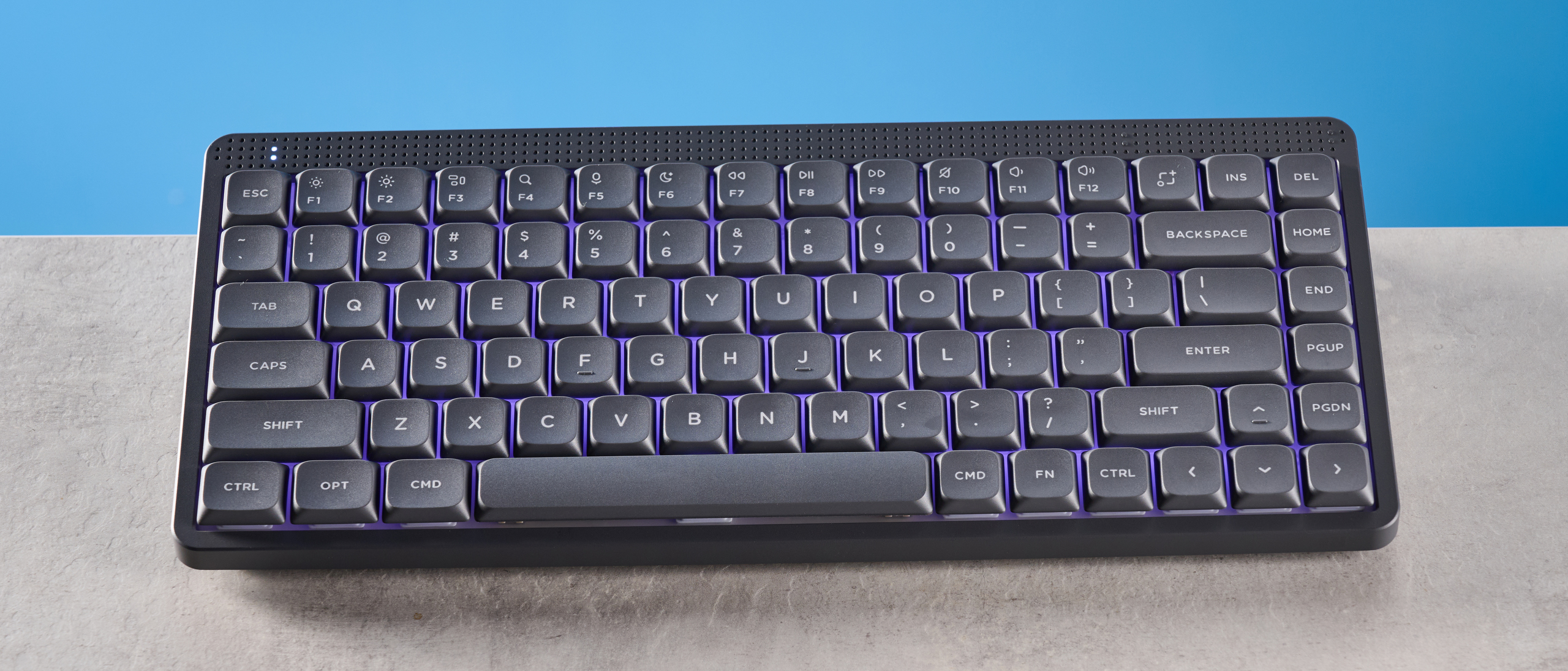 The NuPhy Node75 on a stone surface with a blue background