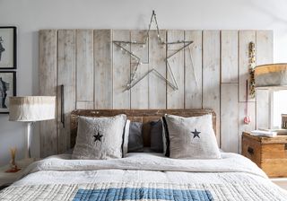 bedroom with white wall and wooden panels and metal star with lighting cord