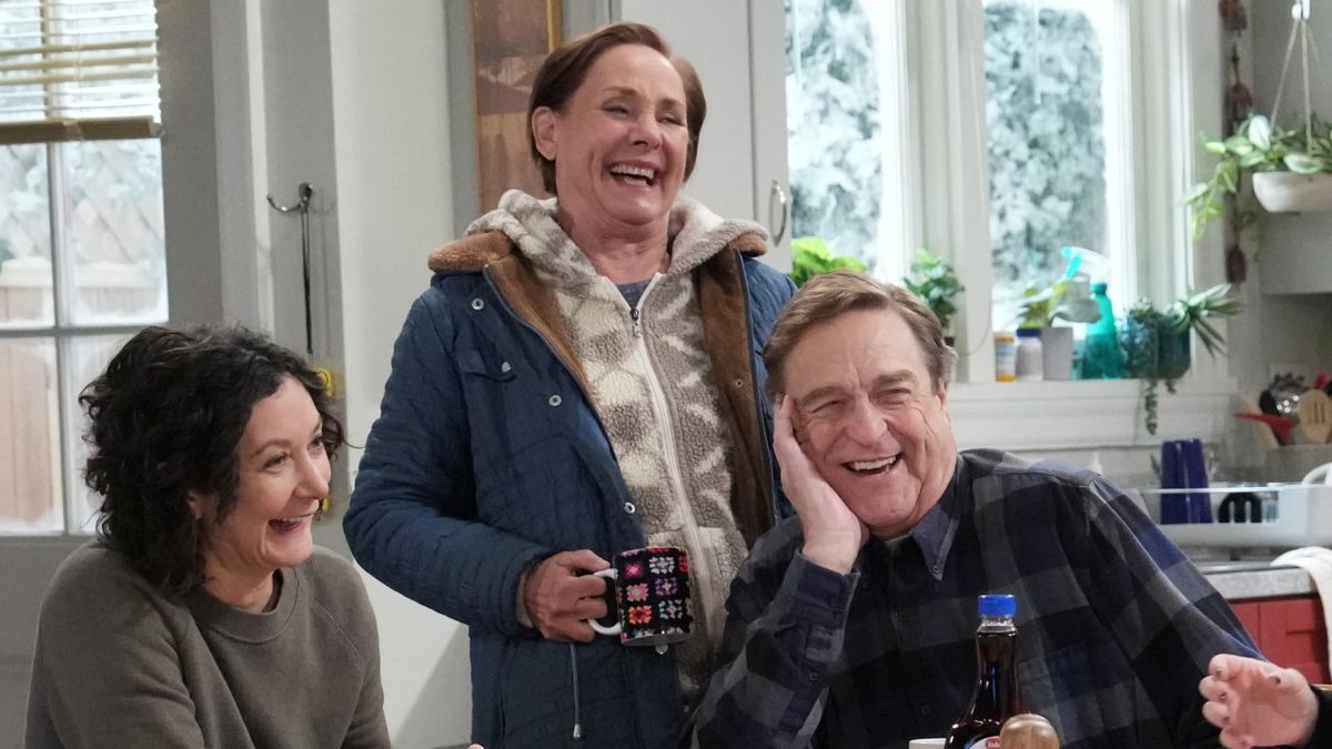 Jackie, Darlene and Dan smiling at table in The Conners