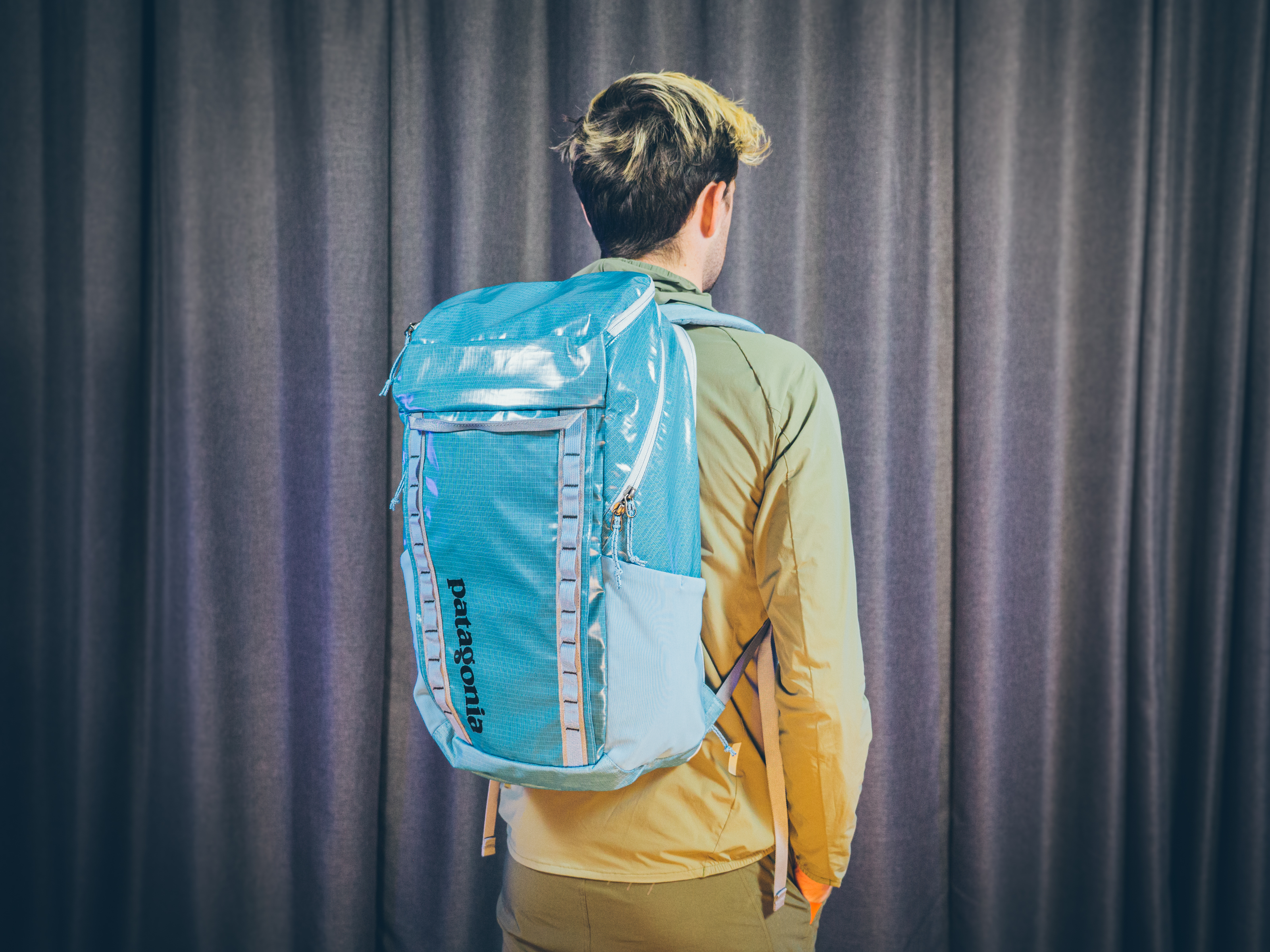 Will Jones, wearing one of the best backpacks for cycling, stands in front of a wall