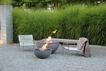 gas fire pits in a modern garden with two relaxing chairs