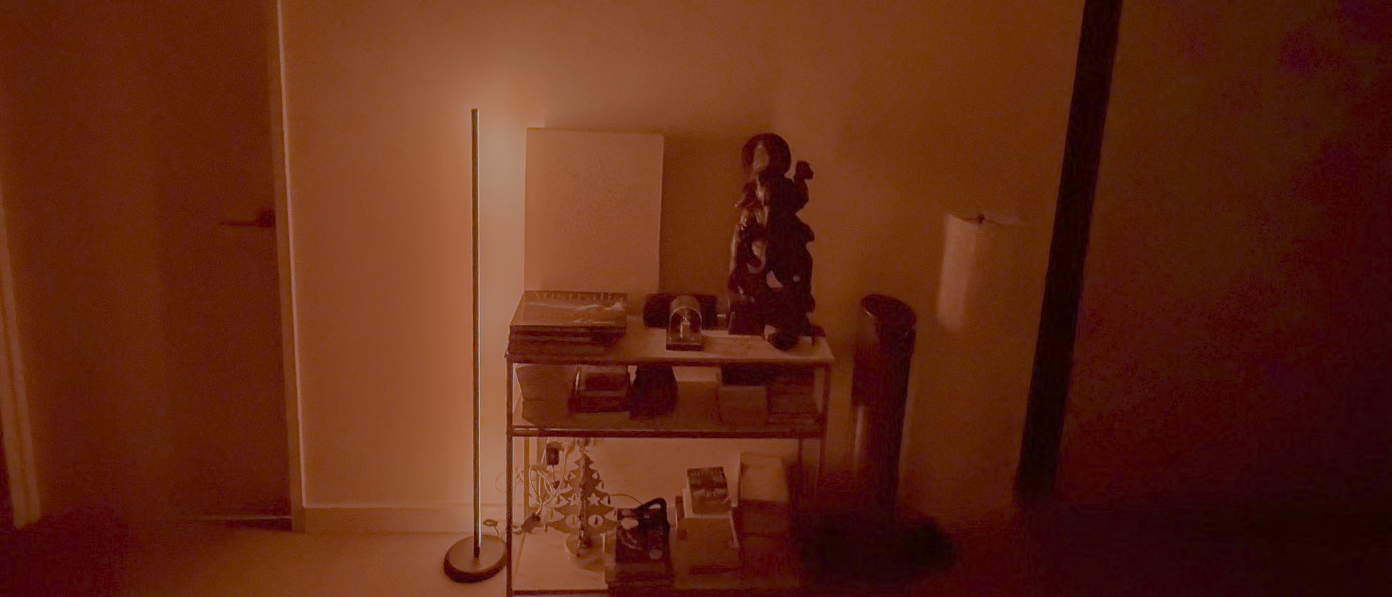 Nanoleaf Smart Multicolor Floor Lamp display red light beside a console table