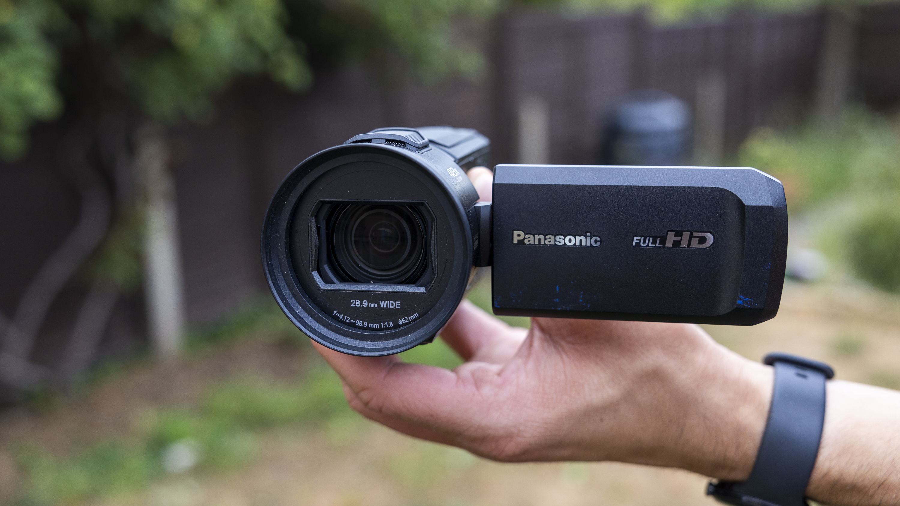 A male holding the Panasonic HC-V900 camcorder