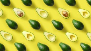 An image of bright green avocados on a bright yellow background