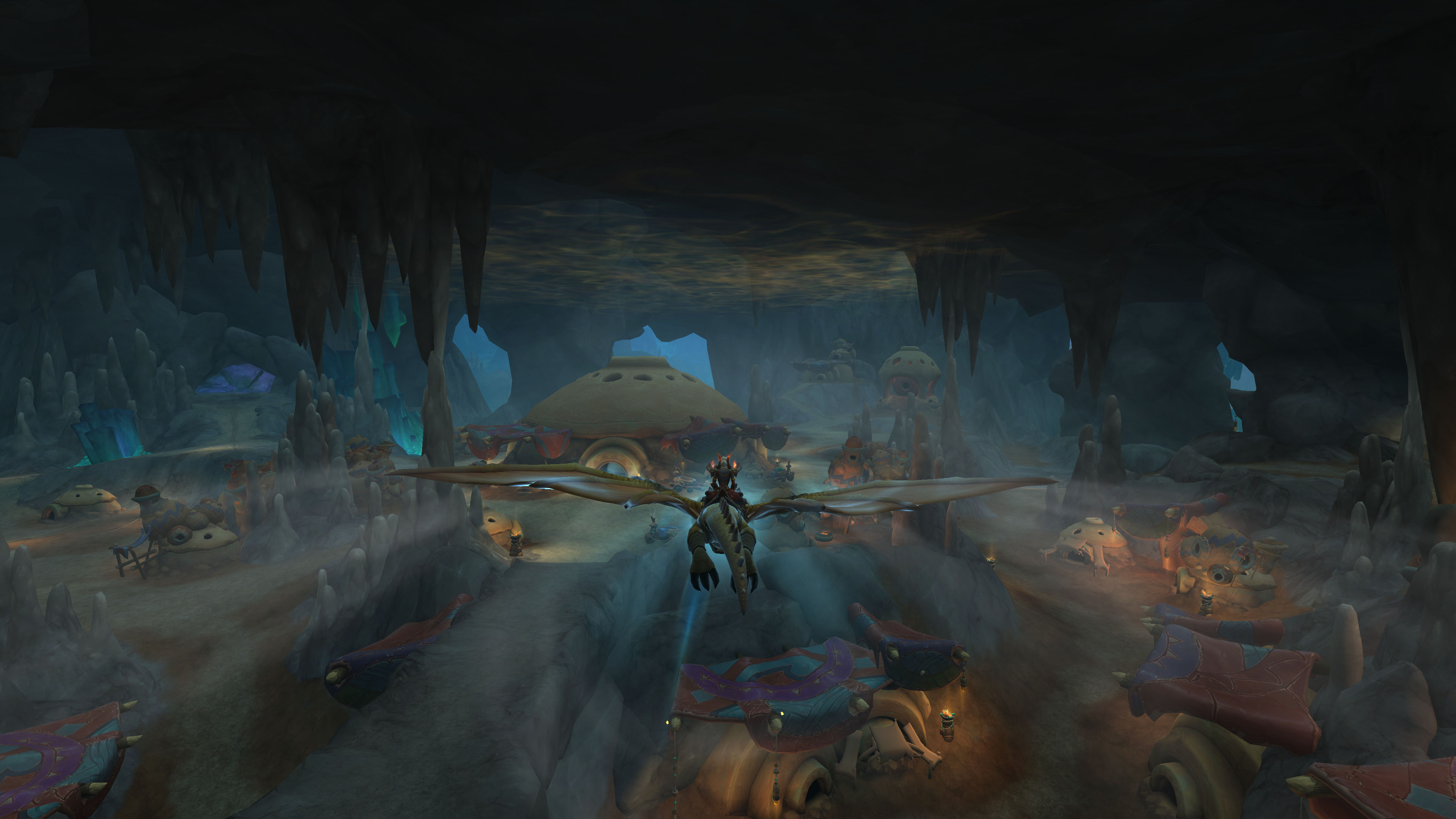 WoW 10.1 update - a player flying their dragonriding mount through a huge cavern