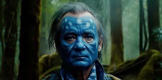 Headshot of Bill Murray in the forest wearing blue face paint.