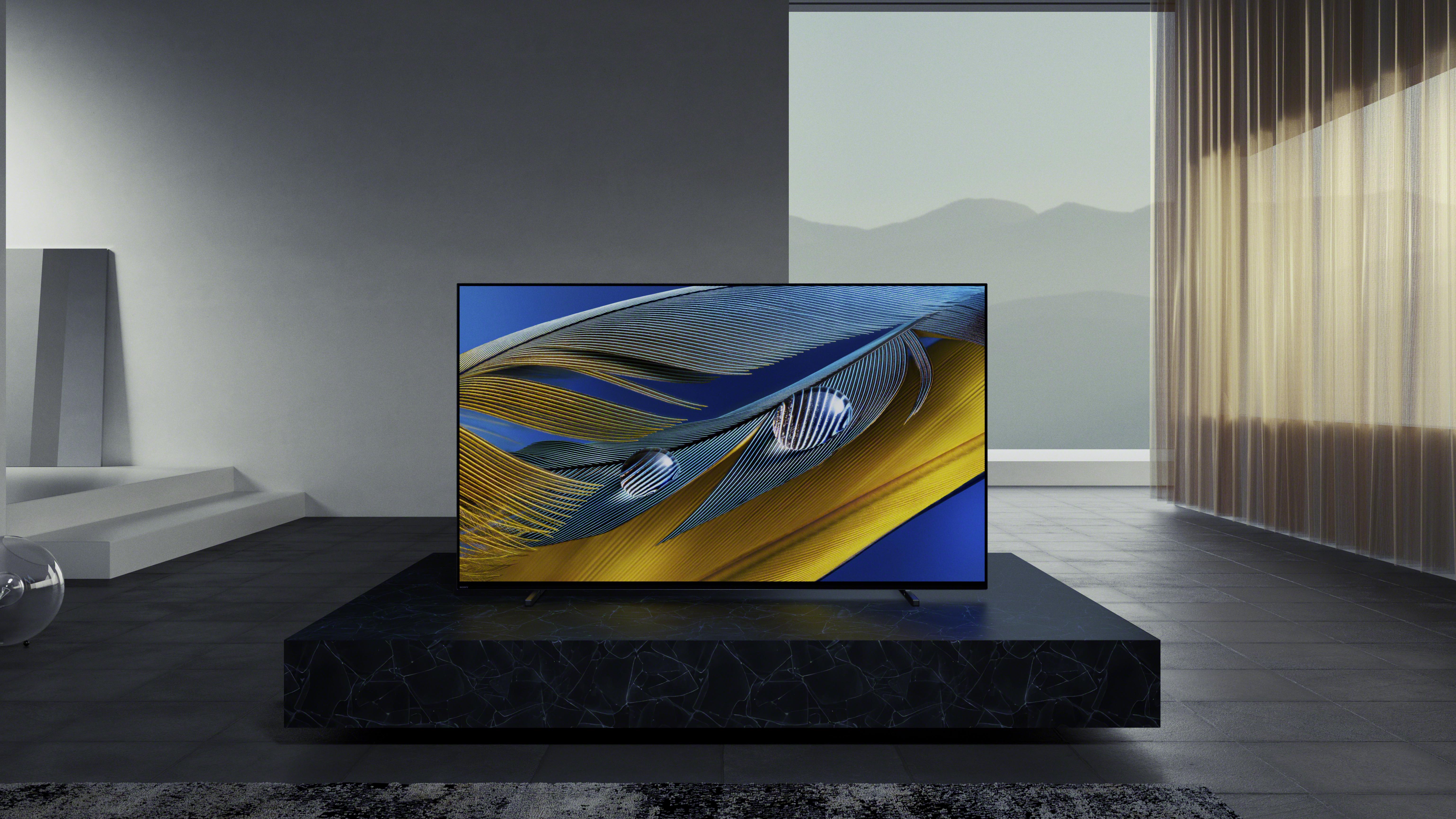 The Sony A80J OLED 4K TV on a black table in a grey room