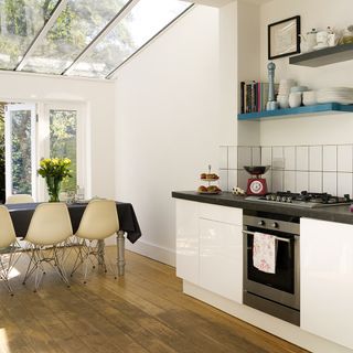 kitchen with white walls wooden flooring dinning table with chair kitchen platform