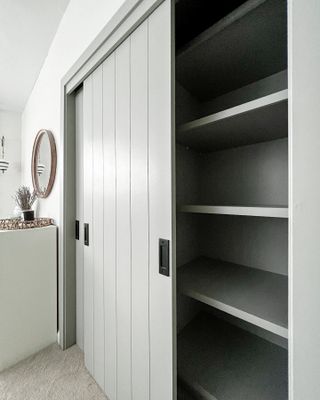 An IKEA PAX wardrobe painted in a soft grey with half open shiplap effect doors
