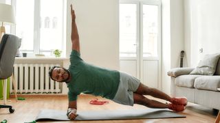 Man doing side plank bodyweight exercises at home