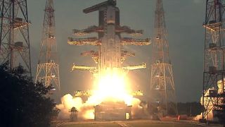 a large white rocket lifts off from its launch pad on a bright yellow plume from its engines.