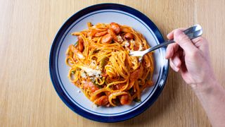 Male cyclist eating a bowl of pasta