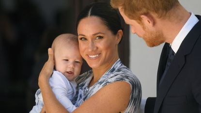 Meghan Markle holds her baby son Archie with Prince Harry looking on during a visit to South Africa